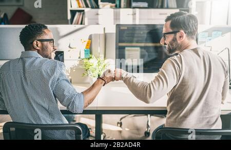 First bump between colleagues at work. Success in business. Everyday work in the office. Stock Photo