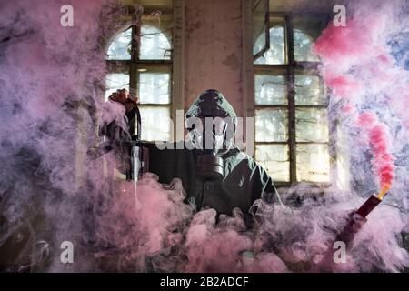 Post apocalyptic survivor in gas mask in the smoke. Environmental disaster, armageddon concept. Stock Photo