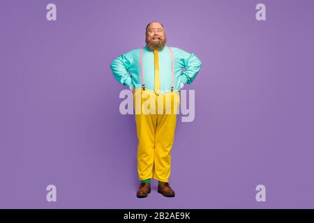 Full length photo of cheerful overweight man feel funky enjoy rest relax wear good look clothes footwear green socks isolated over vivid color Stock Photo