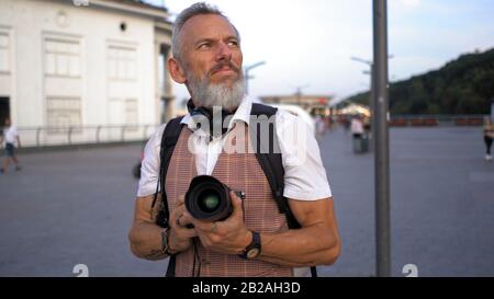 Human Traveler Blogger Looks Around With The Camera In His Hands. Stock Photo