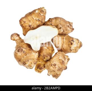 half of tuber on pile of ripe roots jerusalem artichoke (sunroot) vegetables isolated on white background Stock Photo