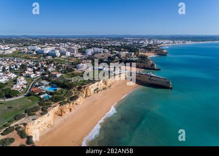 Aerial drone photo of the beautiful coastline along Porches with the Nova and Senhora da Rocha beaches and Armacao de Pera on the background, in Algar Stock Photo