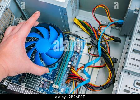 Installing a processor fan on the computer motherboard. Computer repair, PC assembly Stock Photo