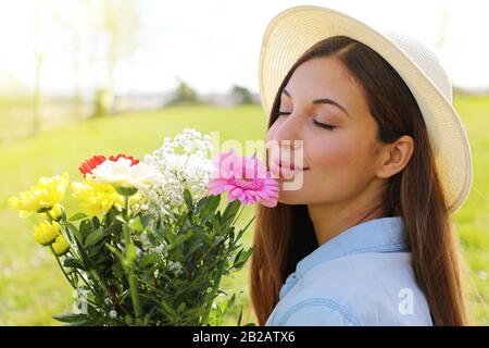 Brazilian pretty beautiful girl smells flowers outdoor Stock Photo