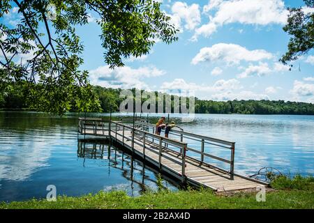 Three children standing on a dock fishing, USA Stock Photo