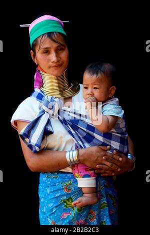 Kayan Lahwi woman carrying her baby and wearing brass neck coils and traditional clothing. The Long Neck Kayan (also called Padaung in Burmese) are a