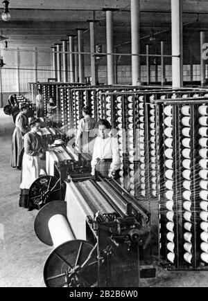 Women work with machines in a cotton spinning mill. Stock Photo