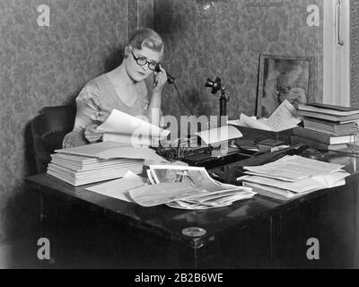 Film scene with office worker (played by Laura la Plante) telephoning at her desk. Stock Photo