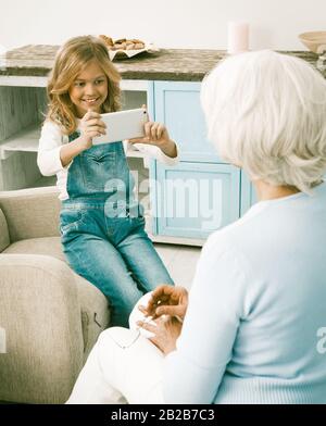 Granddaughter Trying Grandmothers New Phone Stock Photo