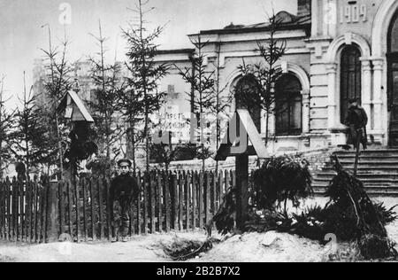 Graves of Ukrainian deputies shot by the Bolsheviks in the main square in the Ukrainian city of Winica. A boy in military uniform stands by the fence next to one of the graves. The Bolsheviks fought against Ukraine's independence efforts. Stock Photo