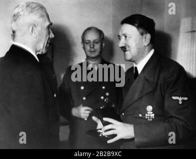 Presentation of the War Merit Cross to Franz von Papen (left) by Adolf Hitler (right). In the centre stands Reich Minister of Foreign Affairs Joachim von Ribbentrop (centre). Stock Photo
