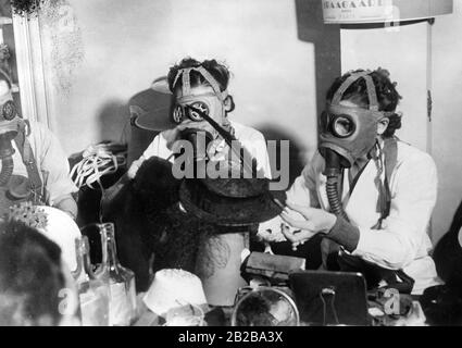 The implementation of the French air protection measures are somewhat exaggerated. In the photo, midinettes (seamstresses) in Paris work with gas masks. Stock Photo