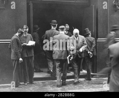 The Great Depression in Great Britain: People talking in front of the stock exchange about the Great Depression. Stock Photo