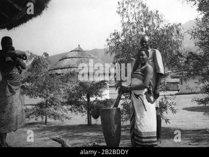 A native woman stamps corn in the Askari camp in Mbeya in German East Africa, today the southern highlands of Tanzania. The photo is undated. Stock Photo