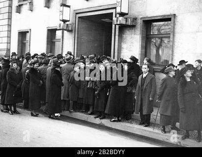 In front of the Reich Chancellery in Berlin stand New Year's well-wishers who want to enter their well-wishes to Chancellor Adolf Hitler into a list. They stand on the sidewalk and wait. Stock Photo