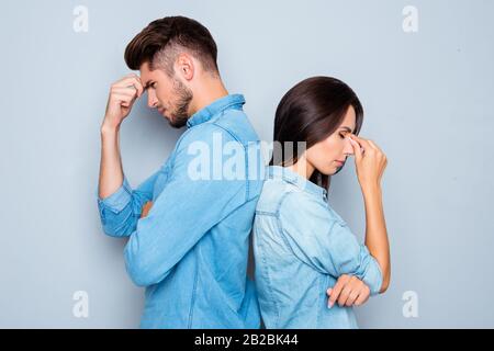 Two sad lovers standing back to back after quarrel Stock Photo