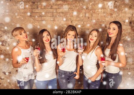 Cheerful young women having party and holding glasses with wine Stock Photo