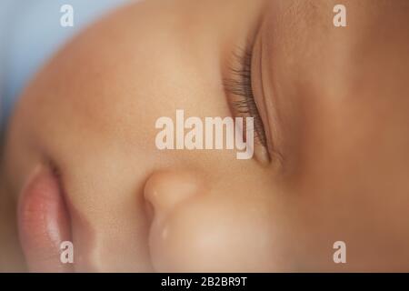 Extremeclose up background of cute mixed-race baby with eyes closed sleeping soundly Stock Photo