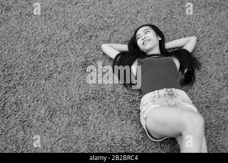Young beautiful Asian woman relaxing at the park Stock Photo