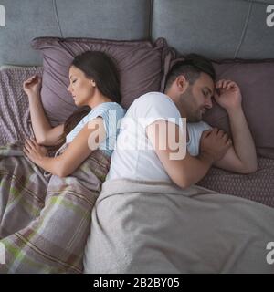 Young couple is sleeping in their bed. Stock Photo