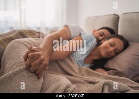 Young couple is sleeping in their bed. Stock Photo