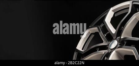 aluminum alloy wheel. Premium cast, the design of the spokes and the wheel rim, a white and black elements on dark background close-up. long layout, c Stock Photo