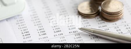 Silver pen lying over financial statistics paper with set of numbers Stock Photo