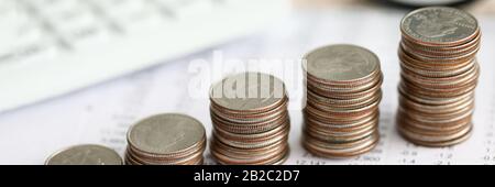 Row of silver coins standing at financial report paper Stock Photo