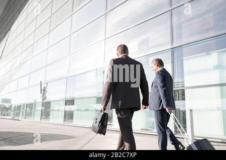 Mature businessmen walking while talking in the airport Stock Photo