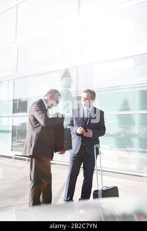 Businessmen standing while talking in the airport Stock Photo