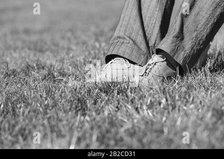 Black and white photo of businessman foot on the grass Stock Photo