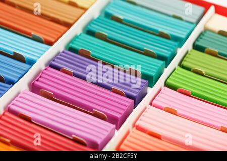 Plasticine in a box of multi-colored pieces in full screen, material for modeling. Texture, background. Stock Photo