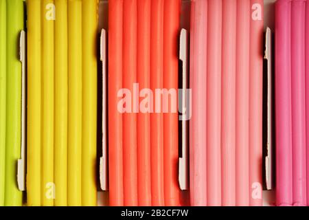 Plasticine in a box of multi-colored pieces in full screen, material for modeling. Close up. Stock Photo