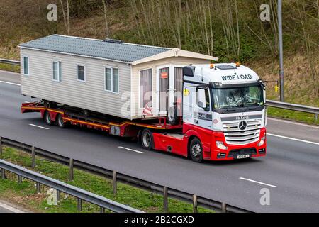 Static caravan Haulage delivery trucks, lorry, transportation, truck, cargo carrier, DAF vehicle, European commercial transport, static caravans industry, wide load M6 at Manchester, UK Stock Photo