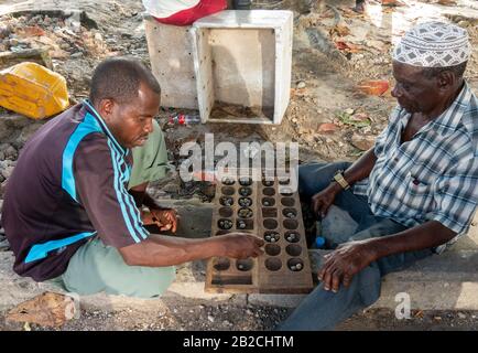 Bao board game is a very popular game in Zanzibar. Here played by two men in Stone town, Zanzibar City Stock Photo