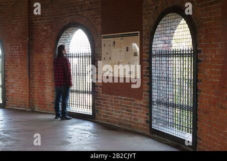 A man looking out a window from the top of the Volunteer Park water tower observation deck in Seattle, Washington, USA. Stock Photo