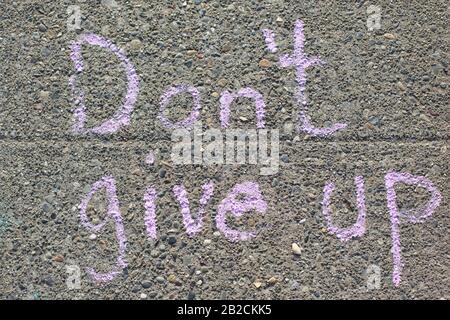 Sign of encouragement handwritten on a sidewalk. Stock Photo