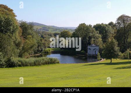 Lush green parkland and woodland in Ireland at Oakfield Park, County Donegal, the oval lake and Nymphaeum on a bright sunny autumn afternoon Stock Photo