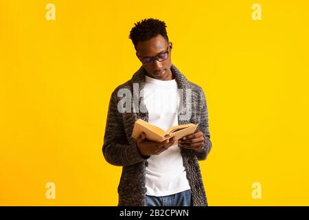 Concentrated young african guy on yellow background Stock Photo