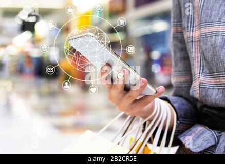 Entire life in smartphone. Woman using mobile phone with virtual icons in shopping mall, closeup. Copy space Stock Photo