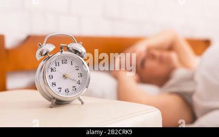 Senior woman lying in bed, woke up at 4 am Stock Photo