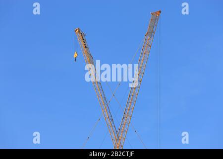 Crane jigs against blue sky Stock Photo