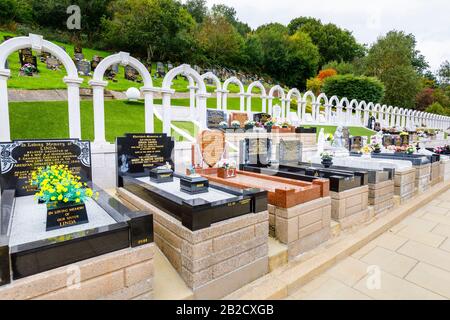 Memorial arches and graves, Bryntaf Cemetery, Aberfan Cemetery, Glamorgan, Wales, resting place of victims who died in Aberfan mining disaster 1966 Stock Photo