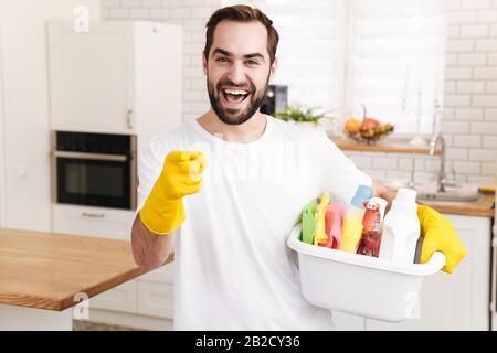 Image of young optimistic positive man househusband indoors pointing to you. Stock Photo