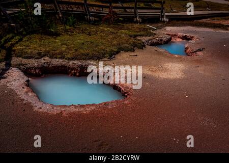 Two small, blue water pools along Artists Paint Pots trail, in Yellowstone National Park Stock Photo