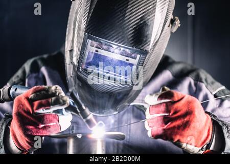 Welder industrial worker welding with argon machine Stock Photo
