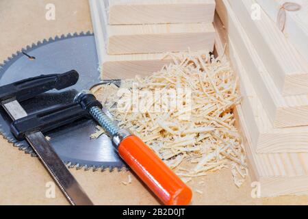Wooden light boards. Sawdust. Chip. Space for text. Saw blade and clamps. Stock Photo