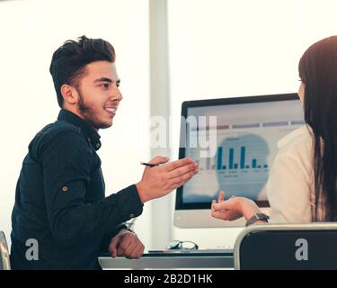 rear view. two employees discuss work issues sitting at the off Stock Photo