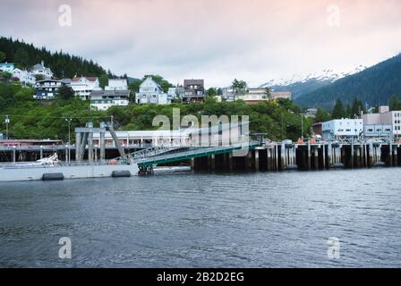 Houses On Hillside In The Alaskan Town Of Ketchikan. Snowcapped Mountains At The Background Stock Photo