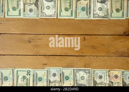 Background made with used dollars banknotes lying on rustic oak wooden table. Stock Photo